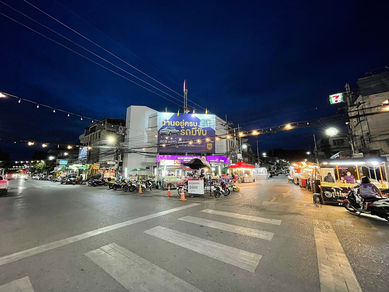 Street stalls and shopfronts at Hua Hin Night Market after dark, photographed in July 2021
